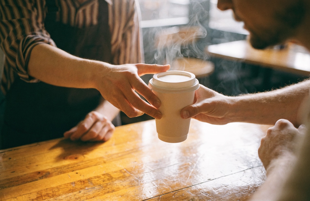 A barista handing a regular customer their free coffee